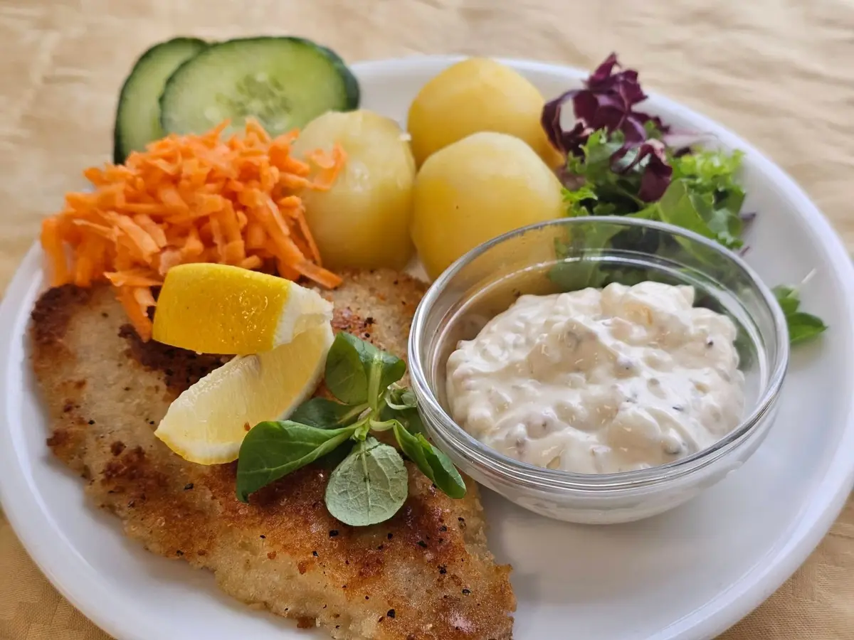 Panerad fisk med potatis, sallad, citron och kall sås