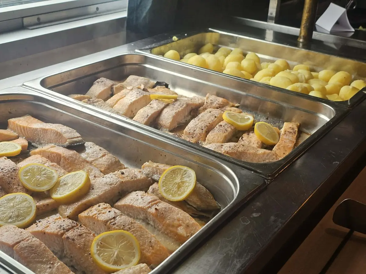 Ugnsbakad lax med citron och kokt potatis i lunchbuffén