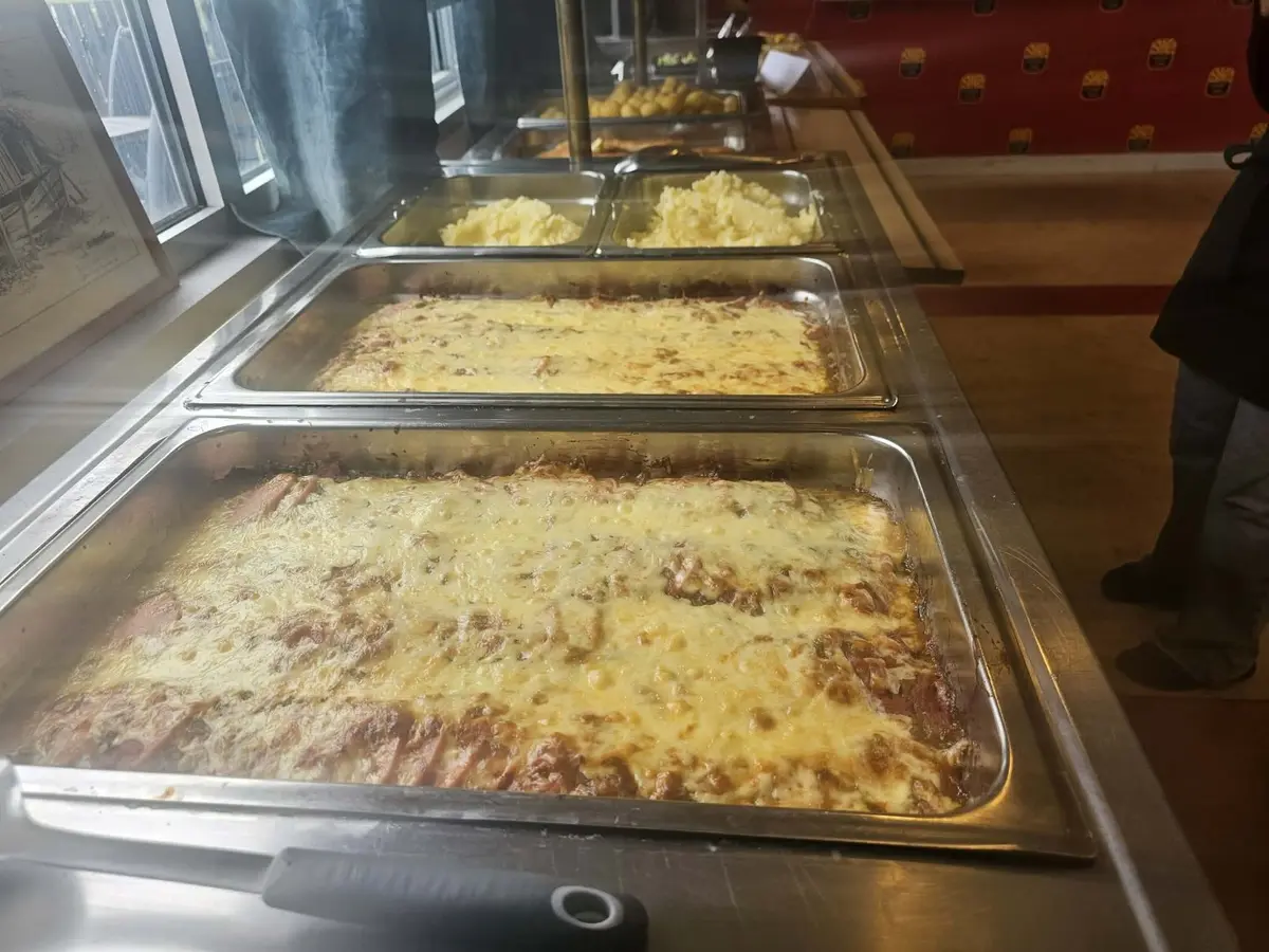 Gratänger uppdukade i den varma lunchbuffén