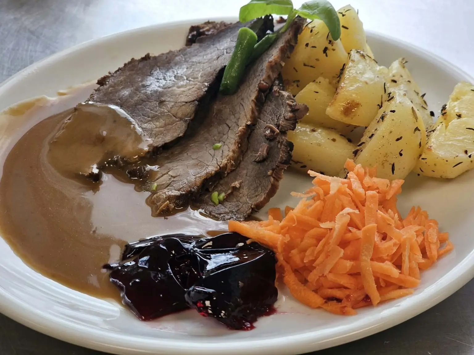 Porterstek med rostad potatis, gräddsås, gelé och rivna morötter